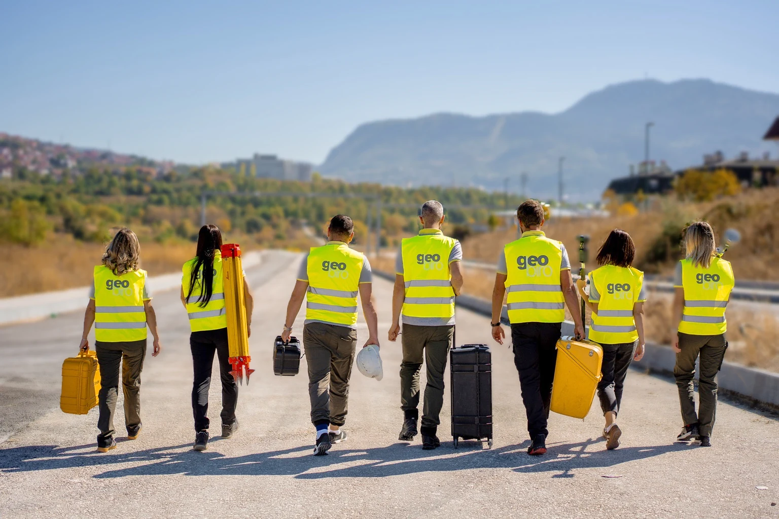 Geobiro surveying team walking together with field equipment